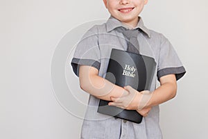 Boy holding Holy Bible book