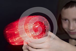 Boy holding imaginary fire gun. red light effect on black background