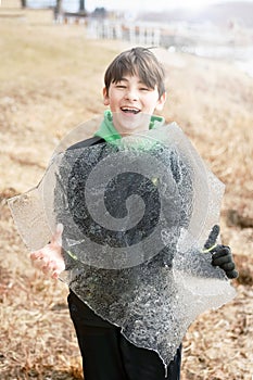 Boy Holding A Large Sheet of Ice from Lake