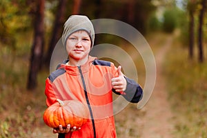 Boy holding an orange pumpkin