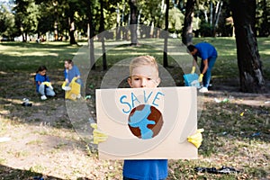 Boy holding placard with globe and