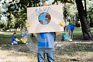 Boy holding placard with globe and