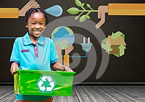 Boy holding recycling box in front of blackboard with recylcing graphics