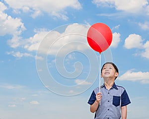 Boy holding red balloon