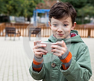 Boy holding smartphone outdoors in autumn