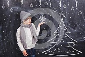 Boy holding a snowflake on the arm