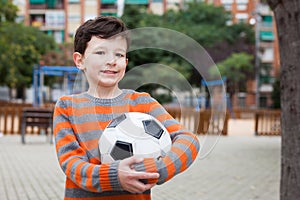 Boy holding soccer ball outdoors