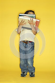 Boy holding stack of books.