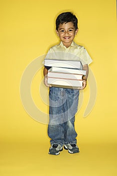 Boy holding stack of books.