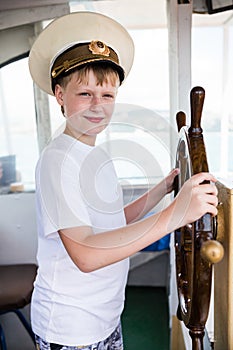 Boy holding the steering wheel of the ship