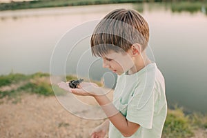 The boy is holding a toad