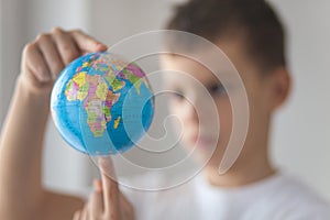 Boy holding toy globus in his hand