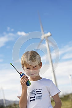 Boy Holding Toy Walkie-Talkie At Wind Farm
