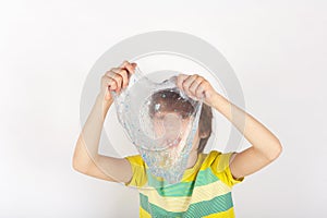 Boy holding a trasparent glitter slime in front of his face