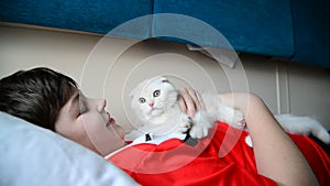 Boy holding a troublesome kitten on train