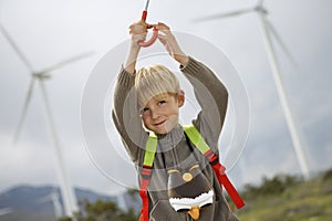 Boy Holding Umbrella At Wind Farm