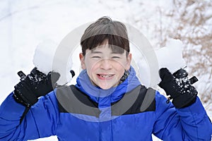 Boy Holding Up Snow Chunks in Winter photo