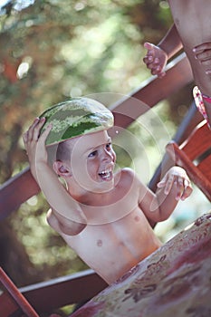 Boy holding watermelon as hat