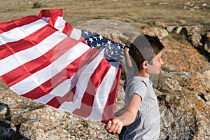 A boy holding waving US flag, beeng a patriot concept