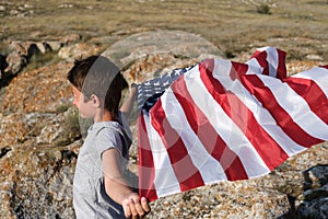 A boy holding waving US flag, beeng a patriot concept