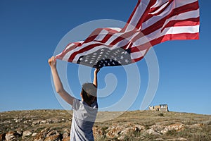 A boy holding waving US flag, beeng a patriot concept