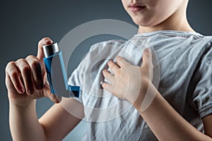 The boy holds an asthma inhaler in his hands to treat inflammatory diseases, shortness of breath. The concept of treatment for