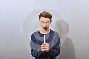 The boy holds a burning candle in front of him and looks at it. Easter service of idolatry photo