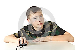 The boy holds a computer mouse in a hand o