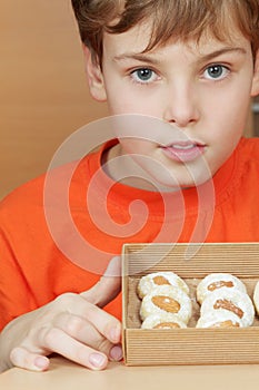 Boy holds open box of corrugated cardboard with cookies