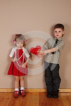 Boy holds red heart for girl