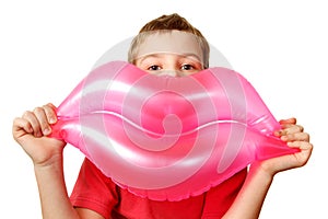 Boy holds toy, inflatable pink lips.