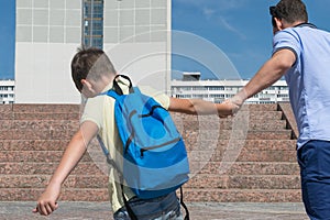 The boy after the holidays does not want to study and go to school, resists his parents photo