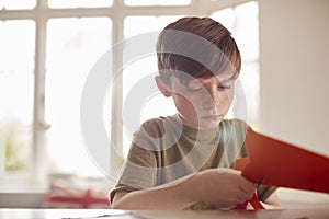 Boy At Home Having Fun Making Halloween Decorations