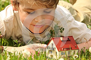 Boy and house model in grass