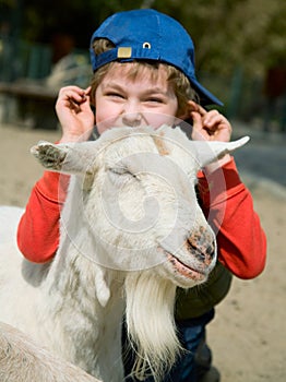 Boy hugging a goat