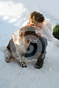 Boy hugging his dog in snow