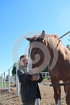 boy hugs horse on farm child and animal friends