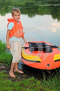 Boy and inflatable boat ashore photo