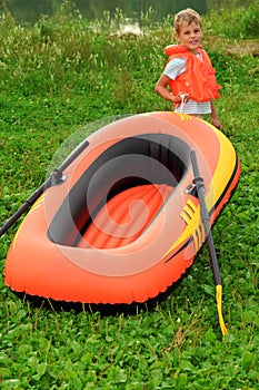 Boy and inflatable boat on lawn
