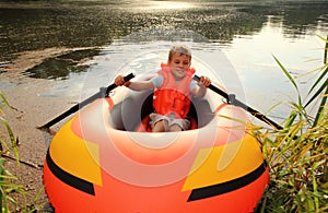 Boy in inflatable boat in water