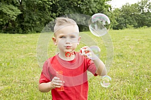 Boy inflates a balloon walking in the park