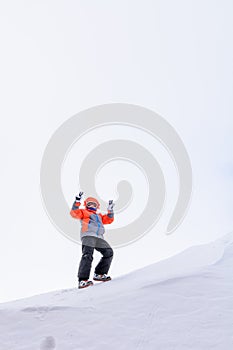 Boy isolated on white background. Cute little kid boy in colorful winter clothes raising arms and climbing mountain, isolated on