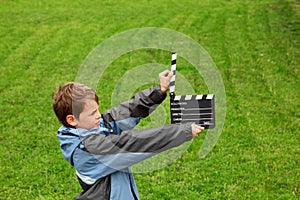 Boy in jacket with cinema clapper board