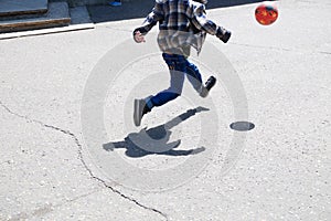 Boy in jump, child running after ball playing football on asphalt, ball jump,soccer team player, training outdoor