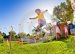 Boy jump over strings passing course of obstacles