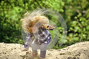 Boy jump on pile of sand on idyllic day