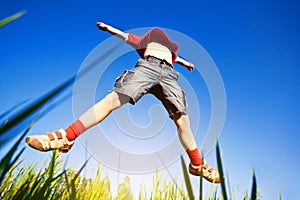 Boy jumping against the blue sky