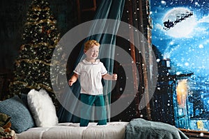 Boy jumping on bed at Christmas