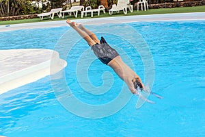Boy jumping in the blue pool