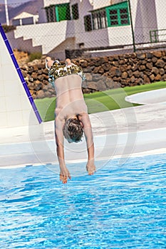 Boy jumping in the blue pool